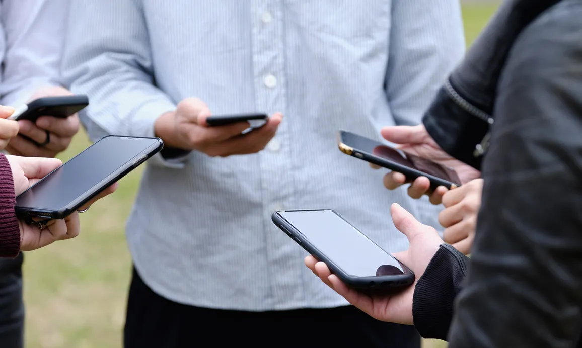 スマートフォンを操作する人々の手